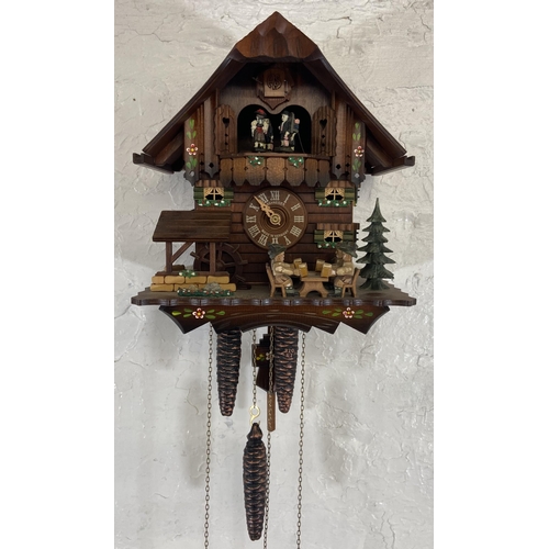 24 - A German Schneider carved and hand painted wooden cuckoo clock - approx. 30cm high x 26cm wide x 19c... 