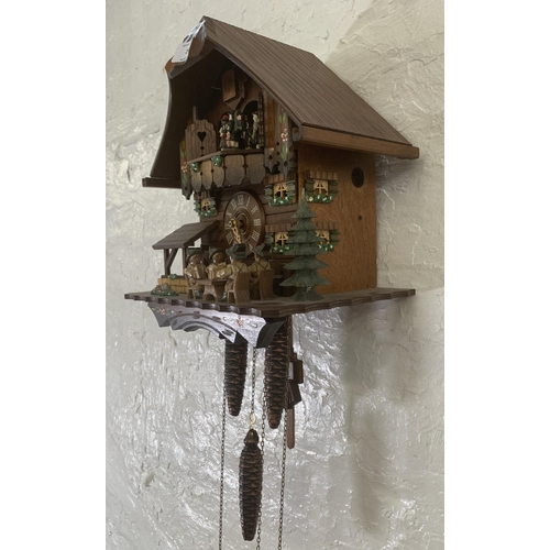 24 - A German Schneider carved and hand painted wooden cuckoo clock - approx. 30cm high x 26cm wide x 19c... 