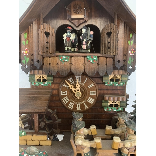 24 - A German Schneider carved and hand painted wooden cuckoo clock - approx. 30cm high x 26cm wide x 19c... 