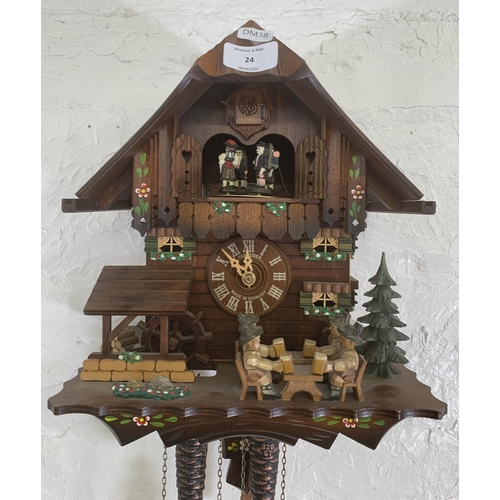 24 - A German Schneider carved and hand painted wooden cuckoo clock - approx. 30cm high x 26cm wide x 19c... 