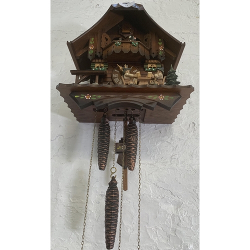 24 - A German Schneider carved and hand painted wooden cuckoo clock - approx. 30cm high x 26cm wide x 19c... 