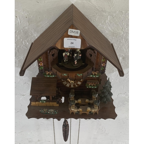 24 - A German Schneider carved and hand painted wooden cuckoo clock - approx. 30cm high x 26cm wide x 19c... 