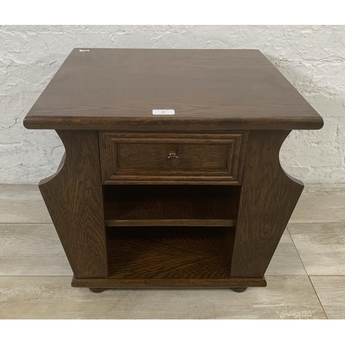 29 - An oak magazine rack side table - approx. 47cm high x 50cm wide x 45cm deep