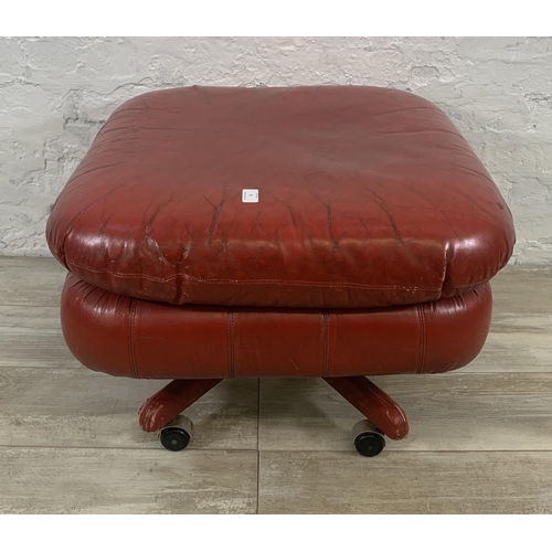 3 - A mid 20th century red leather swivel footstool on castors - approx. 46cm high x 66cm wide