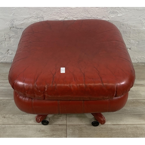 3 - A mid 20th century red leather swivel footstool on castors - approx. 46cm high x 66cm wide