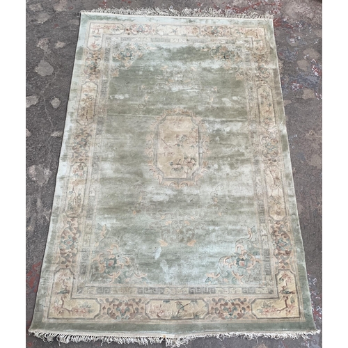 37 - A machine woven green ground floral pattern rug - approx. 190cm x 120xm