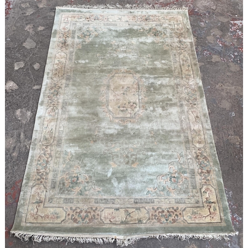 37 - A machine woven green ground floral pattern rug - approx. 190cm x 120xm