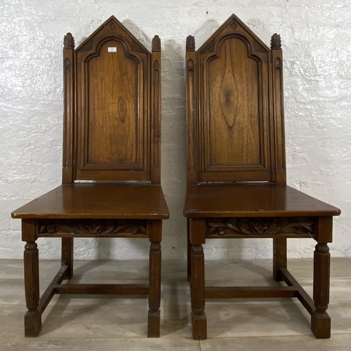 38 - A pair of Gothic style carved oak ecclesiastical type dining/hall chairs with reeded supports and 