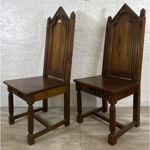 38 - A pair of Gothic style carved oak ecclesiastical type dining/hall chairs with reeded supports and 