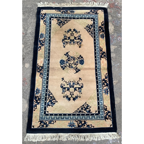 44 - A machine woven pink and blue ground floral pattern rug - approx. 153cm x 92cm