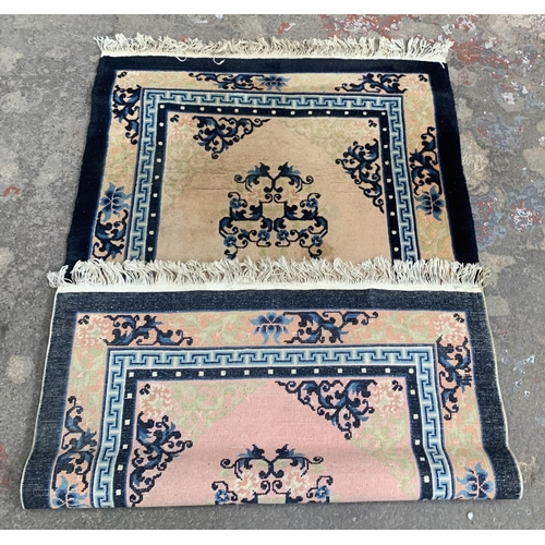 44 - A machine woven pink and blue ground floral pattern rug - approx. 153cm x 92cm