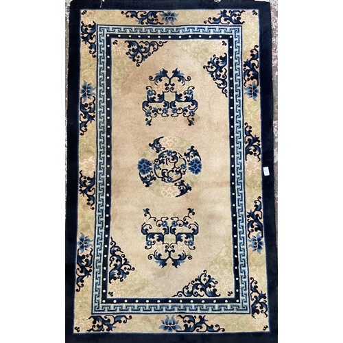 44 - A machine woven pink and blue ground floral pattern rug - approx. 153cm x 92cm