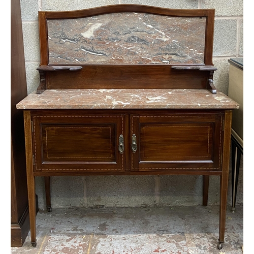 47 - An Edwardian inlaid mahogany and marble wash stand on tapering supports with two cupboard doors and ... 