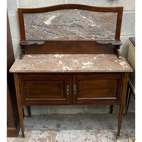 47 - An Edwardian inlaid mahogany and marble wash stand on tapering supports with two cupboard doors and ... 