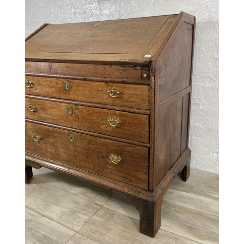 49 - A George III oak bureau on bracket supports - approx. 98cm high x 90cm wide x 55cm deep