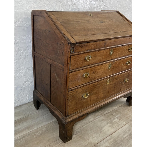 49 - A George III oak bureau on bracket supports - approx. 98cm high x 90cm wide x 55cm deep