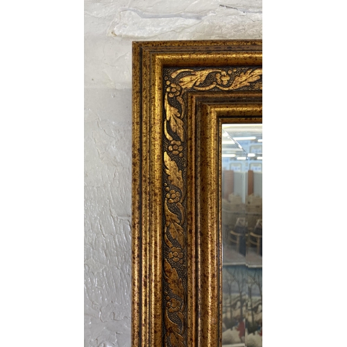 54 - Two bevelled edge wall mirrors, one gilt framed rectangular - approx. 90cm high x 115cm wide and one... 