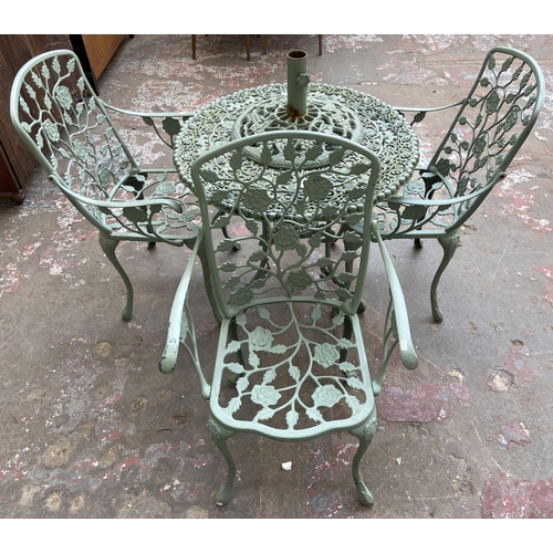 55 - A Victorian style green painted cast metal five piece patio set comprising circular table, three arm... 