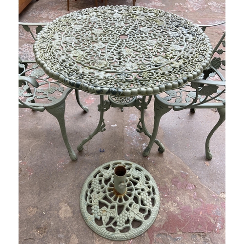 55 - A Victorian style green painted cast metal five piece patio set comprising circular table, three arm... 