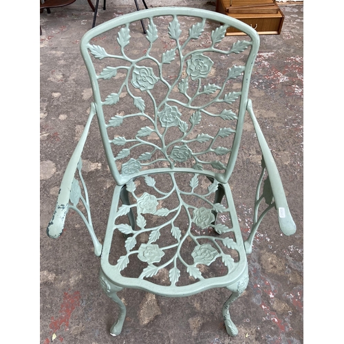 55 - A Victorian style green painted cast metal five piece patio set comprising circular table, three arm... 