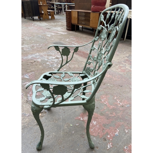 55 - A Victorian style green painted cast metal five piece patio set comprising circular table, three arm... 