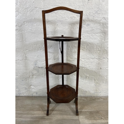 57 - An early 20th century oak three section folding cake stand - approx. 83cm high