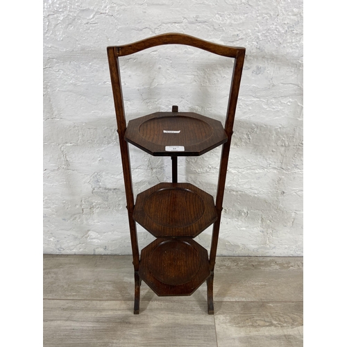 57 - An early 20th century oak three section folding cake stand - approx. 83cm high