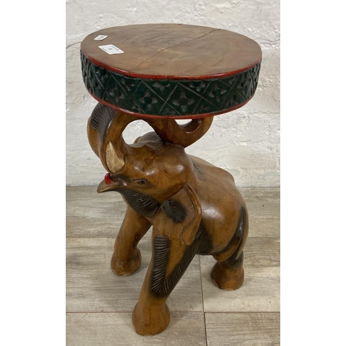 77 - A carved hardwood elephant side table - approx. 52cm high x 25cm diameter