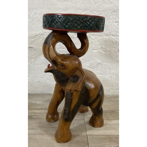 77 - A carved hardwood elephant side table - approx. 52cm high x 25cm diameter