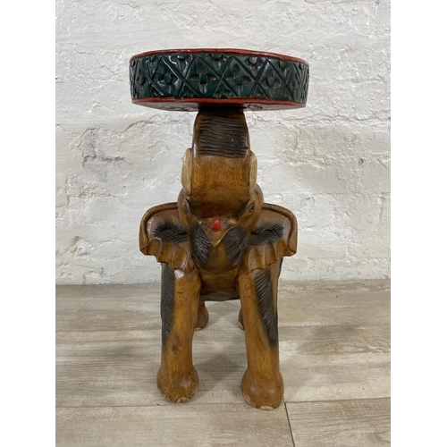 77 - A carved hardwood elephant side table - approx. 52cm high x 25cm diameter