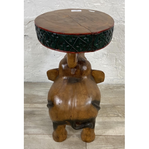 77 - A carved hardwood elephant side table - approx. 52cm high x 25cm diameter