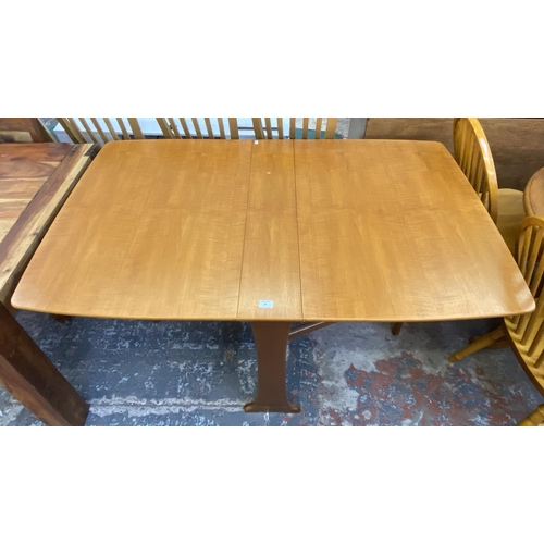 83 - A mid 20th century teak drop leaf gate leg dining table and two Morris of Glasgow elm and brown fabr... 