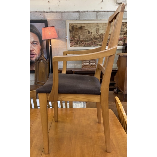 83 - A mid 20th century teak drop leaf gate leg dining table and two Morris of Glasgow elm and brown fabr... 