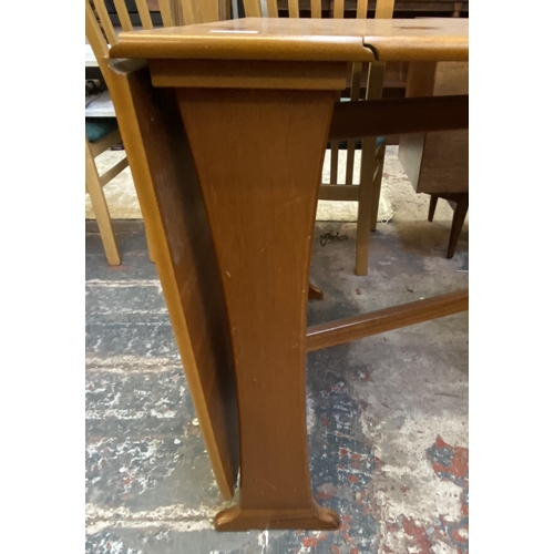 83 - A mid 20th century teak drop leaf gate leg dining table and two Morris of Glasgow elm and brown fabr... 