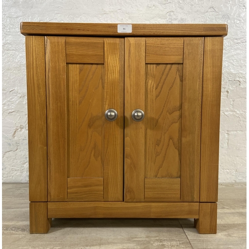 91 - A modern oak two door storage/media cabinet - approx. 59cm high x 56cm wide x 40cm deep