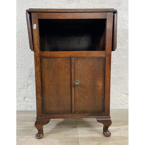 165 - A 1930s oak drop leaf two door cabinet on cabriole supports - approx. 79cm high x 92cm wide x 31cm d... 