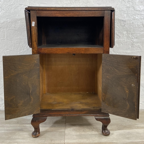 165 - A 1930s oak drop leaf two door cabinet on cabriole supports - approx. 79cm high x 92cm wide x 31cm d... 