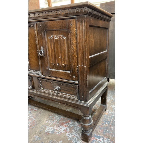 169 - A carved oak two door side cabinet on baluster supports - approx. 85cm high x 92cm wide 43cm deep