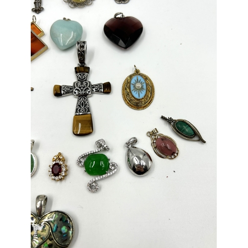 2114 - A collection of gemstone set pendants to include tiger's eye, topaz, garnet, turquoise and moonstone... 