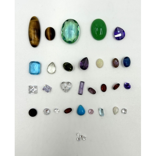 2118 - A collection of gemstones to include tiger's eye, amethyst, blue topaz, garnet etc.