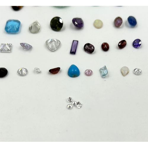 2118 - A collection of gemstones to include tiger's eye, amethyst, blue topaz, garnet etc.