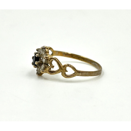 2144 - A hallmarked 9ct gold sapphire and clear gemstone floral cluster dress ring with heart shaped motifs... 