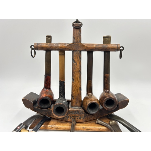 2279 - A 'Tallent' hand made oak HMS Victory novelty pipe stand with twelve smoking pipes to include Pipema... 