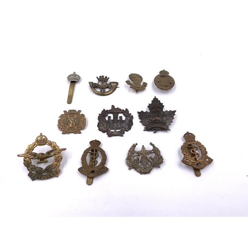 2311 - Eleven military cap badges to include Royal Army Medical Corps, South African etc.