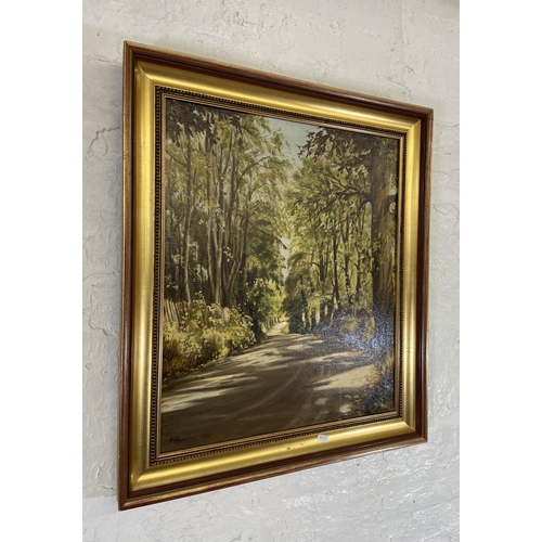 230 - A late 20th century gilt framed oil on canvas of a country lane scene, signed P Robinson and dated 1... 