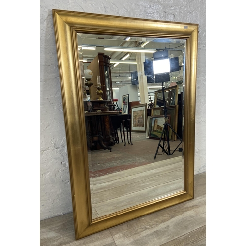 235 - Two items, one modern gilt framed bevel edge wall mirror and one mid 20th century gilt framed oil on... 