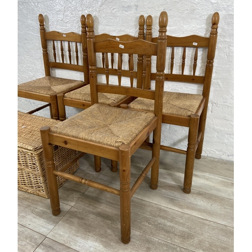 175 - Five pieces of furniture, four pine and rush seated dining chairs and one wicker basket