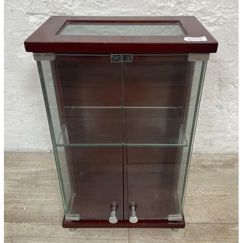 11 - A mahogany effect and glass two door jewellery cabinet - approx. 36cm high x 21.5cm wide x 13cm deep