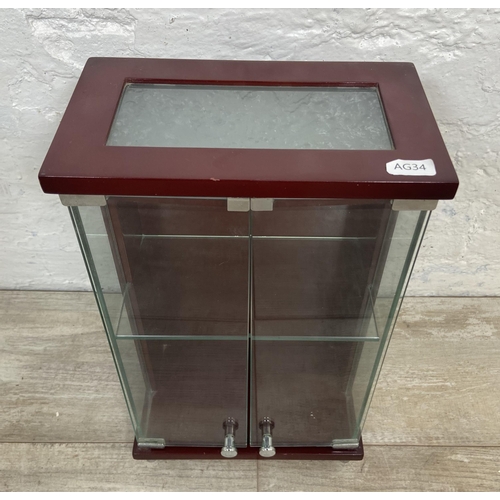 11 - A mahogany effect and glass two door jewellery cabinet - approx. 36cm high x 21.5cm wide x 13cm deep