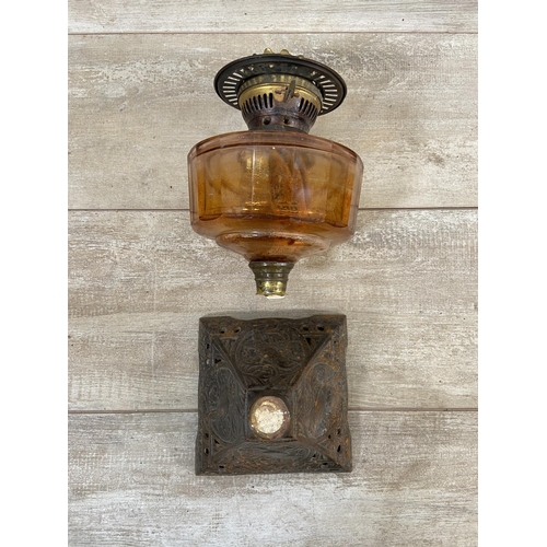 177 - Three oil lamps, two vintage brass and one Victorian cast iron with orange glass reservoir